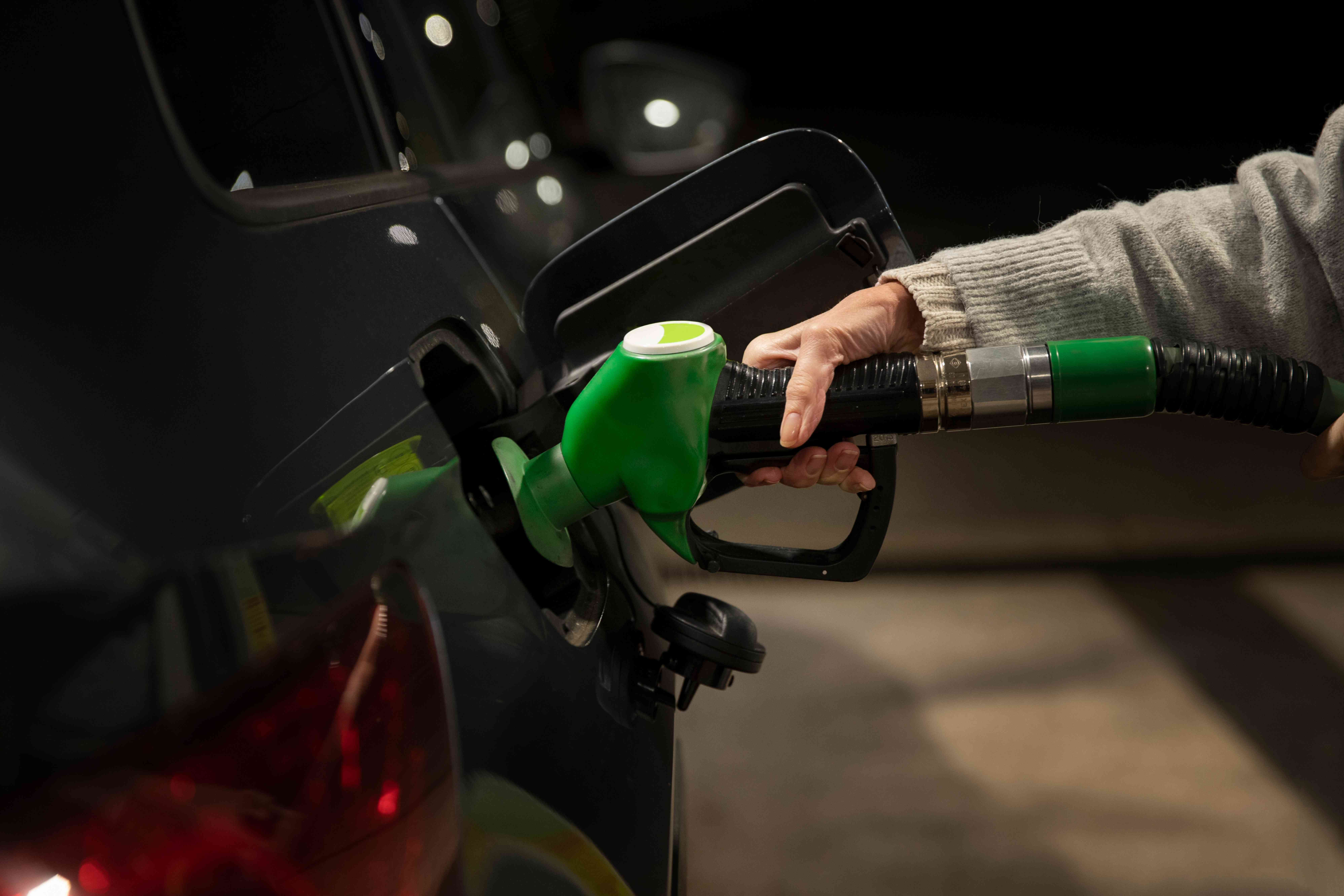 Mano presionando la bomba de gas para repostar combustible